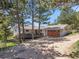 Exterior view of home with attached garage, deck, mature trees, and a long driveway at 258 Post Boy Rd, Boulder, CO 80302