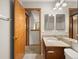 Bathroom featuring a granite countertop vanity, and view of the hallway with bedroom at 4111 W Kenyon Ave, Denver, CO 80236