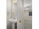 Stylish half-bathroom with pedestal sink and round mirror, conveniently located near additional living space at 4111 W Kenyon Ave, Denver, CO 80236