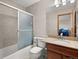 Bathroom with tiled shower and a vanity with granite countertop and storage at 4111 W Kenyon Ave, Denver, CO 80236