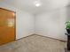Cozy bedroom with a door, natural light from a window, and carpeted floor at 4111 W Kenyon Ave, Denver, CO 80236