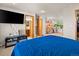 Bedroom with large TV, closet, ensuite bath, and comfortable blue comforter at 4111 W Kenyon Ave, Denver, CO 80236
