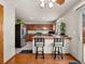 Kitchen featuring stainless steel appliances, breakfast bar with stools, wood floors, and ample cabinet space at 4111 W Kenyon Ave, Denver, CO 80236