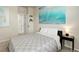 Well-lit bedroom with minimalist decor, geometric bedding, and connecting bathroom at 7099 E 123Rd Pl, Thornton, CO 80602