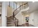 Grand foyer with a curved staircase featuring wood banisters and wrought iron spindles at 7099 E 123Rd Pl, Thornton, CO 80602