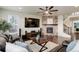 Cozy living room featuring a stone fireplace, hardwood floors, ceiling fan, and large TV screen at 7099 E 123Rd Pl, Thornton, CO 80602