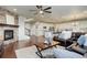 Inviting living room with a stone fireplace, hardwood floors, comfortable seating, and open to the kitchen at 7099 E 123Rd Pl, Thornton, CO 80602
