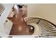Curved staircase with carpeted steps, dark iron railing and wood floors at 7099 E 123Rd Pl, Thornton, CO 80602