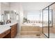 Bright bathroom with a soaking tub, tiled surround, and a glass-enclosed shower at 27290 E Nova Cir, Aurora, CO 80016