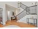 Elegant foyer with hardwood floors, a staircase with dark metal railings, and decorative tables at 27290 E Nova Cir, Aurora, CO 80016