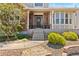 Inviting covered entry and front porch with brick accents and curated landscaping at 27290 E Nova Cir, Aurora, CO 80016