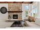 Cozy living room with stone fireplace, wooden beams, plush seating, and plenty of natural light at 27290 E Nova Cir, Aurora, CO 80016