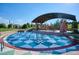 Community park featuring a splash pad with a tiled surface, covered seating, and manicured landscaping at 851 Elmhurst Dr # A, Highlands Ranch, CO 80129