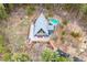 Aerial view of an A-frame cabin featuring a spacious deck with a hot tub and surrounded by tall green trees at 352 Apache Rd, Evergreen, CO 80439