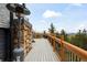 Open deck with stone heater and wooden railings overlooking a scenic mountain view at 352 Apache Rd, Evergreen, CO 80439