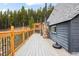Spacious deck with wooden railings and a heater for enjoying outdoor living in a serene forested setting at 352 Apache Rd, Evergreen, CO 80439
