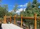 View of deck showcasing wood railings and outdoor plants with views of lush mature trees at 352 Apache Rd, Evergreen, CO 80439