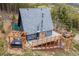 Aerial view of a home with a wraparound deck, a hot tub, and surrounded by lush forest at 352 Apache Rd, Evergreen, CO 80439