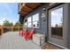 Inviting front porch with red Adirondack chairs, stylish decor, and a gray front door at 352 Apache Rd, Evergreen, CO 80439