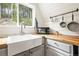 The kitchen features a farmhouse sink, butcher block counters, and a view of the forest at 352 Apache Rd, Evergreen, CO 80439