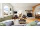 Cozy living room with a stone fireplace, large windows, and comfortable seating at 352 Apache Rd, Evergreen, CO 80439