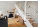 Bright living room features a stone fireplace, wood floors, and a staircase leading to the upper level at 352 Apache Rd, Evergreen, CO 80439