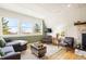 Cozy living room with three large windows, wooden floors, and a stylish area rug at 352 Apache Rd, Evergreen, CO 80439