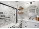 Bathroom featuring a white marble shower, a vanity, and a round mirror at 11687 Decatur Dr, Westminster, CO 80234