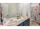 Well-lit bathroom featuring a double sink vanity and a decorative shower curtain at 11687 Decatur Dr, Westminster, CO 80234