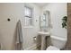 Quaint bathroom with white pedestal sink and toilet with a window and patterned towel at 1532 N High St # 1, Denver, CO 80218