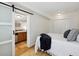 Cozy bedroom featuring a barn door leading to a kitchenette, wood floors and closet at 1532 N High St # 1, Denver, CO 80218