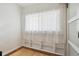 Bright bedroom with a large window covered by white curtains and built-in shelving at 1532 N High St # 1, Denver, CO 80218