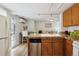Open-concept kitchen with stainless dishwasher, wood cabinetry, granite countertops and a view to the living area at 1532 N High St # 1, Denver, CO 80218