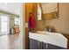 Modern half-bathroom features sleek vanity with sink and mirror, accented by warm wall color at 5552 Odessa St, Denver, CO 80249