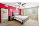 Bedroom featuring red accent wall, large bed, and ample natural light at 5552 Odessa St, Denver, CO 80249