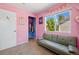 Bright bedroom has pink walls, a window with natural light and a gray sofa at 5552 Odessa St, Denver, CO 80249