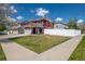 Charming two-story red home featuring a well-manicured lawn and bright white fence at 5552 Odessa St, Denver, CO 80249