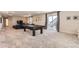 Large basement recreation space with pool table and sliding glass door to the outside at 14440 Hop Clover Trl, Parker, CO 80134