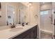 This double vanity bathroom features quartz counters, two sinks and shower access at 14440 Hop Clover Trl, Parker, CO 80134