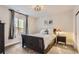 Cozy bedroom with a dark sleigh bed, stylish light fixture, and neutral walls at 14440 Hop Clover Trl, Parker, CO 80134