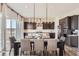 Beautiful dining area with modern chandelier and chef's kitchen in the background at 14440 Hop Clover Trl, Parker, CO 80134