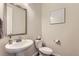 A charming powder room features a pedestal sink, decorative mirror and neutral decor at 14440 Hop Clover Trl, Parker, CO 80134