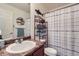 Bathroom with tub shower, vanity, and striped curtain at 10699 Durango Pl, Longmont, CO 80504