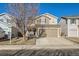 Two-story house with tan and brown siding, attached garage, and a landscaped front yard at 10699 Durango Pl, Longmont, CO 80504