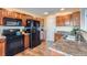 Kitchen features wood cabinets, black appliances, and granite countertops at 10699 Durango Pl, Longmont, CO 80504