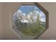 An octagonal window frames a view of snow-capped mountains and trees against a cloudy sky at 218 Highland Ter, Breckenridge, CO 80424