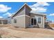 Back exterior featuring gray siding, a sliding glass door, and a corner lot at 9314 Biscay St, Commerce City, CO 80022
