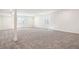 Large basement area with two egress windows and neutral carpeting, offering a versatile space at 9314 Biscay St, Commerce City, CO 80022
