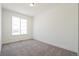 Bright bedroom featuring neutral carpeting, a large window, and white walls at 9314 Biscay St, Commerce City, CO 80022