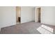 Bright bedroom featuring neutral carpeting, white walls, and doorway access to an ensuite bathroom at 9314 Biscay St, Commerce City, CO 80022